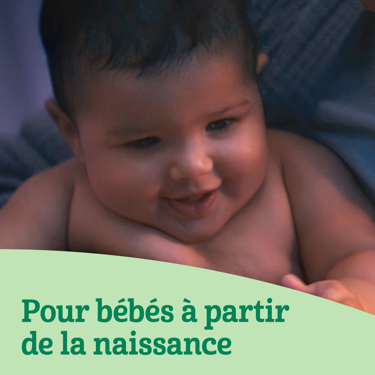 Nourrisson souriant regardant vers le bas.
