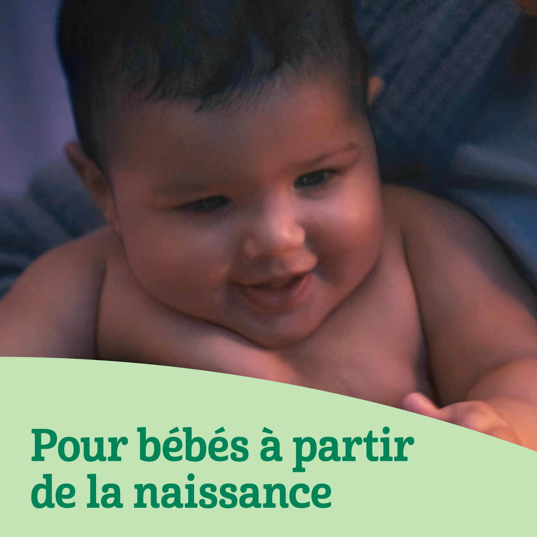 Nourrisson souriant regardant vers le bas.